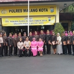 Kapolres Malang Kota AKBP Asfuri didampingi Ketua Bhayangkari Cabang Malang Kota Susi Asfuri, serta Kabag Sumda Kompol Tutik D, foto bareng 27 purnawirawan di halaman Mapolres, Rabu (02/01/2019). Foto: IWAN IRAWAN/BANGSAONLINE