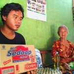 Nenek Siti Aminah bersama salah satu cucunya usai menerima bantuan sembako dan uang dari wartawan Tulungagung. Foto: FERI WAHYUDI/ BANGSAONLINE