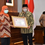 PRESTASI: Gubernur Khofifah menyerahkan penghargaan dari Kemendagri ke Pj Bupati Sidoarjo Hudiyono, Kamis (16/10). foto: ist.