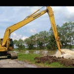 Alat berat sedang memperbaiki tanggul anak Sungai Bengawan Solo secara darurat, agar air tidak meluber dan menggenangi ratusan hektare tanaman padi. foto: EKY NURHADI/ BANGSAONLINE