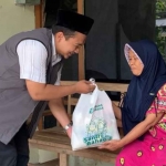 Ketua Yayasan Lumbung Kebaikan Kediri, Fuad Fauzi, saat menyerahkan bingkisan lebaran kepada salah satu lansia. Foto: Ist