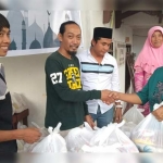 Ketua PWI Jember Sigit Maryato dan bos dari Kinansyah Abdul Salam, sedang membagikan sembako.