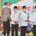 Bupati Gus Yani didampingi Camat Tambak Agung Endro Dwi Setyo Utomo dan pejabat Forkopimcam saat penyerahan bantuan. foto: SYUHUD/ BANGSAONLINE