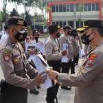 Kapolres Gresik memberikan reward kepada anggota berprestasi. (foto: SYUHUD/ BANGSONLINE)