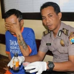 Pelaku saat diamankan bersama barang bukti oleh Polisi.