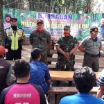 Sutarno, KRPH Pojok BKBH Perhutani KPH Kediri diapit Babinsa Desa Jugo Sertu Yanuar P dan Bhabinkamtibmas Desa Jugo Bripka Modasir, saat memberi penyuluhan kepada warga sekitar hutan di lereng Gunung Wilis. foto: MUJI HARJITA/ BANGSAONLINE