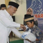 KH Kikin Abdul Hakim (Gus Kikin) secara simbolik memberikan santunan kepada anak yatim, fakir miskin, janda  dari dana Lembaga Sosial Pesantren Tebuireng (LSPT) Kabupaten Jombang. foto: Romza/BANGSAONLINE