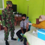 Babinsa Koramil 0811/06 Plumpang, Sertu Sumargono saat mengawal vaksinasi pelajar di SMPN 3 Plumpang.