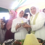 Khofifah Indar Parawansa saat memotong tumpeng dan diberikan kepada Bupati Kediri Haryanti Sutrisno di kantor Muslimat NU Kabupaten Kediri. Foto: ARIF K/BANGSAONLINE