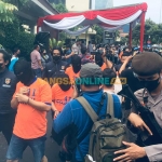 Petugas saat menggelandang para pengedar uang palsu di Mapolda Jatim. Foto: RUSMIYANTO/BANGSAONLINE