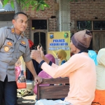 Kapolres Kediri Kota, AKBP Miko Indrayana sedang berdialog dengan warga yang mengikuti pengobatan gratis. (foto: ist).