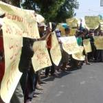 Ratusan massa membentangkan sejumlah poster saat Demo di depan Kantor Dispendik. foto: hadi prayitno/BANGSAONLINE