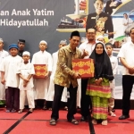 Jajaran manajemen Hotel @Hom Premiere saat menyerahkan santunan kepada anak yatim dan warga. foto: SYUHUD/ BANGSAONLINE