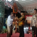 Bupati Malang Sanusi (tengah) menyerahkan gunungan ke Ki Dalang Purbo Nasikin Dipocarito sebagai tanda dimulainya wayang kulit.