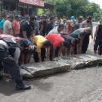 Proses pemindahan beton yang diletakkan di tengah jalan oleh warga.