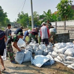 Satgas TMMD Sidoarjo dan warga bersih-bersih sungai di Desa Penambangan Balongbendo, Sabtu (25/5/2024)