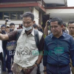 Bupati Nganjuk, Taufiqurrahman, menyambut petugas KPK yang hendak melakukan penggeledahan terhadap ruang kerjanya. foto: BANGSAONLINE