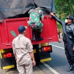 Petugas menghentikan salah satu truk untuk pemeriksaan angkutan.