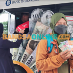 Seorang warga usai melakukan penukaran uang di mobil kas keliling BI. Foto: MUJI HARJITA/ BANGSAONLINE