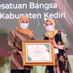 Bupati Kediri Hj. Haryanti Sutrisno ketika menerima penghargaan juara II atas prestasi Bakesbangpol Kabupaten Kediri dari Gubernur Jatim, Hj. Khofifah Indar Parawansa. foto: kominfo kediri