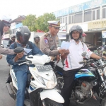 Anggota Satlantas Polres Ngawi saat membagikan brosur di perempatan Kartonyono.