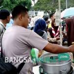 Aditya, pedagang pentol, saat melayani pelanggannya. Ia berharap event seperti Karnaval Inbox digelar lebih sering. foto: HERMAN/ BANGSAONLINE