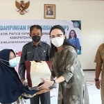 Ketua TP PKK Kabupaten Kediri, Eriani Annisa saat menyerahkan bantuan kepada salah satu anak yatim. foto: ist.