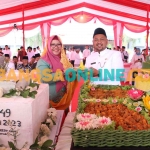 Bupati Gresik, Fandi Akhmad Yani, saat memotong tumpeng kemudian diberikan kepada wakilnya, Aminatun Habibah. Foto: SYUHUD/BANGSAONLINE