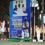 Baliho PPKM berikut pocong dan keranda mayat yang berada di depan Pasar Pon Trenggalek.