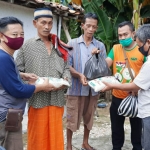 Erick (kiri), wartawan HARIAN BANGSA Biro Pamekasan bersama FRPB saat membagikan sembako terhadap masyarakat terdampak Covid-19.