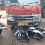 Petugas saat memeriksa kondisi sepeda motor korban yang masih terjepit di bawah truk.