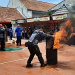 Petugas Lapas Kelas IIB Tuban saat mencoba memadamkan kobaran api.