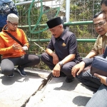 Kepala DPUPR Kota Malang Hadi Santoso (tengah berpeci) saat mendampingi rombongan Komisi C DPRD sidak di jembatan Muharto, Senin (7/10) lalu. foto: IWAN IRAWAN/ BANGSAONLINE