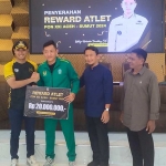 Bupati Lindra menyerahkan reward pada atlet PON dan kafilah lomba MTQ berprestasi.