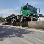 Kondisi truk yang nyangkut di pembatas jalan.