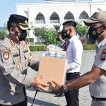 Kapolresta Sidoarjo Kombes Pol. Kusumo Wahyu Bintoro menyalurkan paket kesehatan dalam apel Senin (26/7/2021) pagi di Mapolresta Sidoarjo.