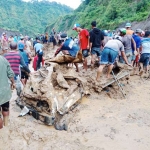 Warga saat membantu evakuasi truk pasir yang tertimbun longsor. Foto: ARIF K/BANGSAONLINE