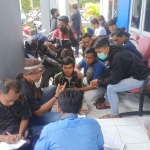 Pembina GBMB, Dwi Agus Budiarto (duduk bertopi), saat bersama puluhan buruh PT Muroco di Disnaker Jember untuk perundingan bipartit.