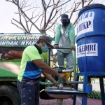 Petugas DLHKP Kota Kediri saat mengisi tandon air untuk keperluan cuci tangan. foto: ist.