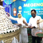 Gubernur Khofifah bersama Wagub Emil dan Sekda Heru Tjahjono di depan gunungan apem saat acara megengan online di Gedung Negara Grahadi.