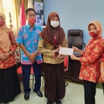 Ny. Aini Zadim Effisiensi saat menyerahkan bantuan kepada siswa SMAN 2 Batu, Kamis (12/11).