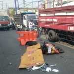 Korban saat ditutupi dengan kardus setelah terlindas truk tangki di Raya Waru, Jembatan Layang Waru, Rabu (12/6/2024).