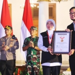 Penyerahan Rekor Muri oleh Customer Relation Manager Museum Rekor Dunia Indonesia, Lutfi Syah Pradana kepada Gubernur Jawa Timur, Khofifah Indar Parawansa di Halaman Gedung Negara Grahadi Surabaya, Sabtu (31/12) malam.