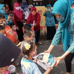 Ferry Silviana Feronica, Ketua Tim Penggerak PKK Kota Kediri ketika membagikan paket menu ikan. (foto: ist)