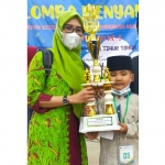 Siswa TK Lathifiyah 4 Lamongan, Gilbi Maleeq Jibrani,  bersama guru pembina saat menerima piala.