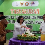 Pj Wali Kota Kediri, Zanariah, saat memotong tumpeng dan diberikan kepada anggota PWRI tertua. Foto: Ist