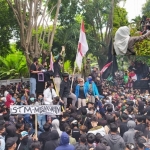 Ribuan massa peserta aksi demo tolak Omnibus Law di Banyuwangi. Inset: Polwan berhijab sedang membagikan minuman ke para demonstran.