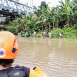 Petugas BPBD Kota Kediri saat memantau aktivitas warga yang hendak mengambil ikan di Sungai Brantas.  Foto: Ist