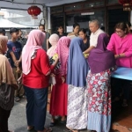 Warga yang antre di rumah Ie Ching, Kelurahan Kaliwungu, Kecamatan/Kabupaten Jombang, untuk mendapatkan sembako. foto: RONY S/ BANGSAONLINE