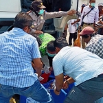 Jasad korban sedang dievakuasi petugas dibantu warga.